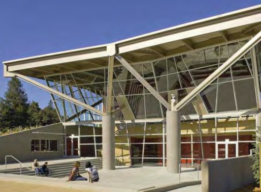 Steel struts surmounting massive concrete columns complement the oaks facing the lobby and support the exposed structure of the roof above the depressed entry courtyard sheltered by a branching structure designed to inspire spontaneous outdoor performances.