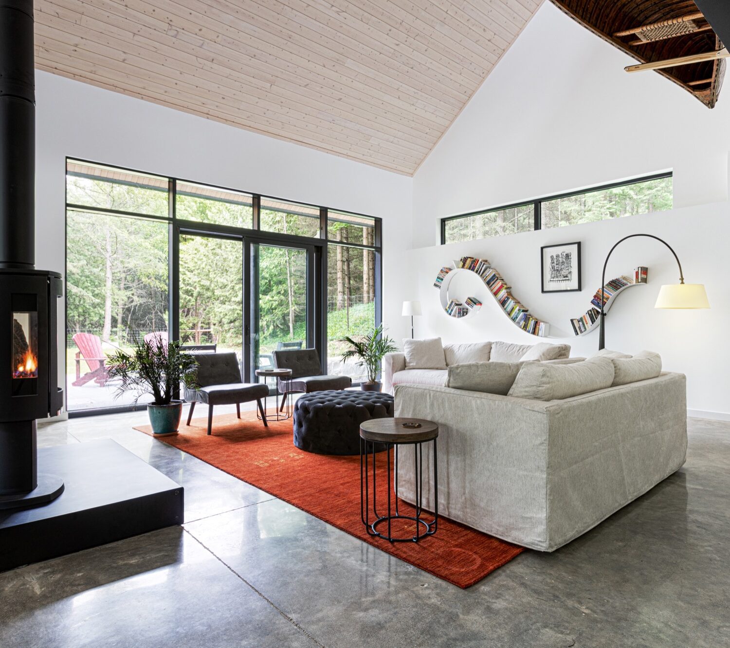 Interior of cabin, showing white couch and red carpet with bookshelf on wall