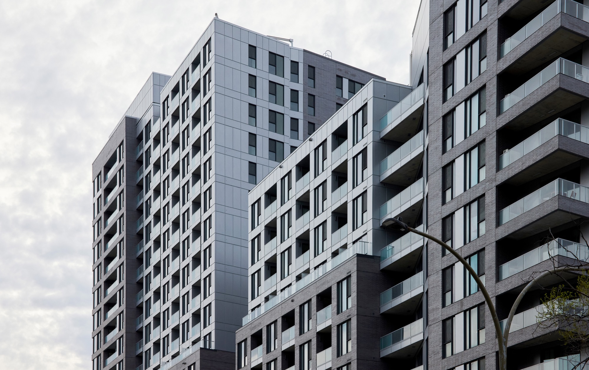Upper levels of August & Louis condos against cloudy sky
