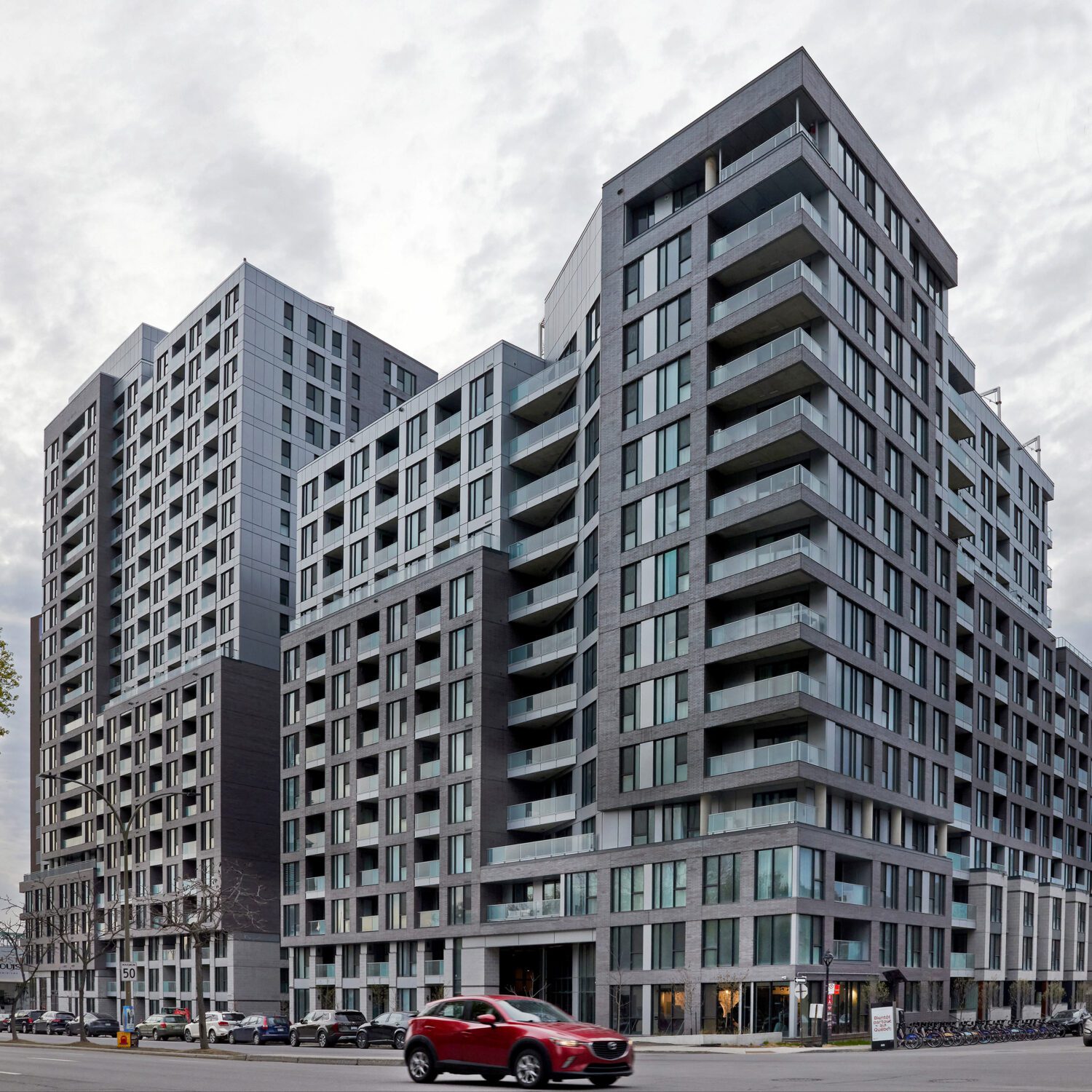August and Louis Condos, Montreal QC, red car driving by