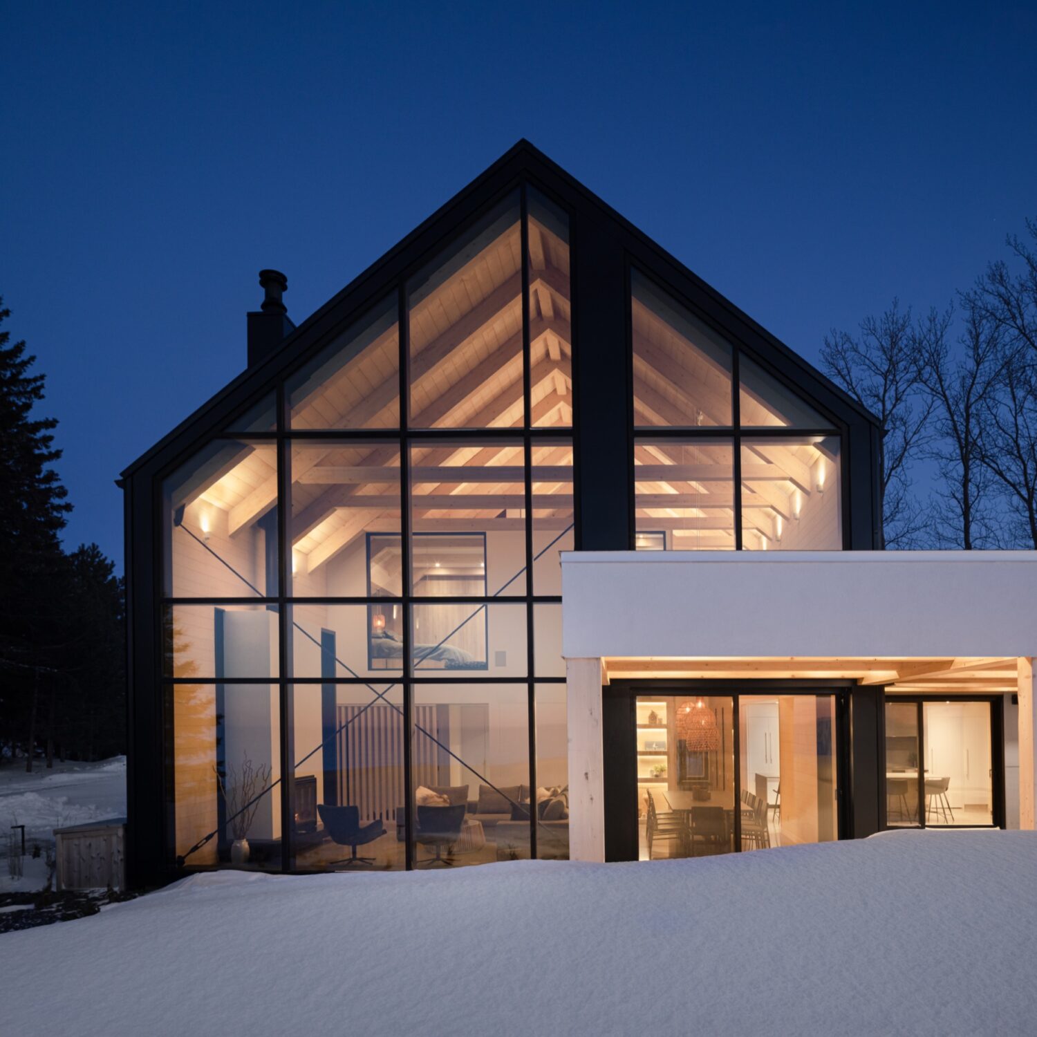 Front view of residence exterior, showing lit up house against night sky