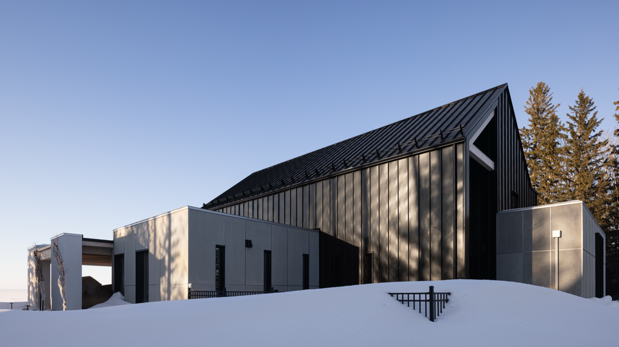 Exterior of residence showing black exterior panelling, set in the snow